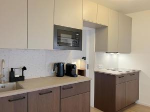 a kitchen with white cabinets and a coffee maker on a counter at Seestadt Apartment I Sauna I Parkplatz I Zentral in Haltern