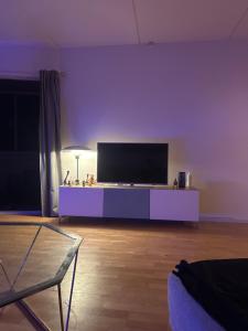 a living room with a flat screen tv on a table at Lejlighed in Måløv