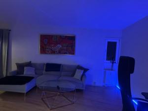 a living room with a couch and a blue light at Lejlighed in Måløv