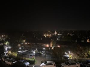 a city at night with cars parked in a parking lot at Lejlighed in Måløv