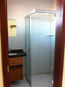 a bathroom with a glass shower and a sink at Pousada Brisa Do Pontal in Fortim