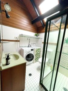 a bathroom with a sink and a washing machine at The Loft in South West Rocks +6 photos