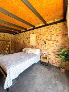 a bedroom with a bed and a brick wall at The Loft in South West Rocks