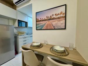 a dining room table with chairs and a picture on the wall at Mahrak Villa - VSH in Porto De Galinhas