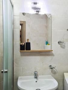 ein Badezimmer mit Waschbecken und Spiegel in der Unterkunft The Place in Skopje + 34 Fotos