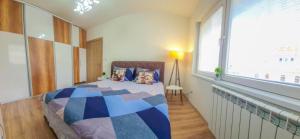 ein Schlafzimmer mit einem Bett und einem großen Fenster in der Unterkunft The Place in Skopje