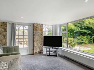 a living room with a flat screen tv and windows at 4 Bed in Beaumaris 94501 in Llanddona