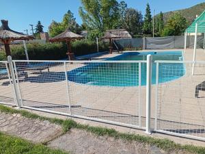 a fence in front of a swimming pool at Cabañas Yaqui in Potrero de los Funes