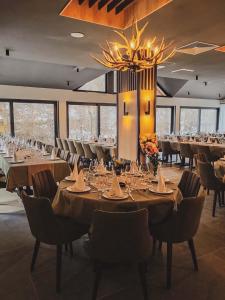 een eetkamer met tafels en stoelen en een kroonluchter bij Janjska Kuća in Šipovo