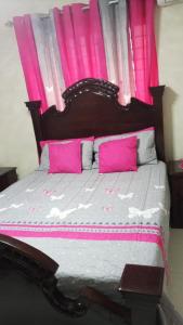 a bedroom with a large bed with pink curtains at Hermoso apartamento in Santo Domingo +9 photos