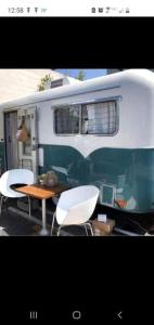 a table and chairs in front of a trailer at Pleasant Cozy Airstream with Amazing Stargaze and Farm Views in Maryland in Seneca Highlands