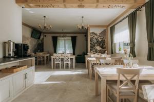 a kitchen and dining room with tables and chairs at Willa Janowa in Bukowina Tatrzańska