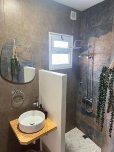 un baño con lavabo y ducha en Coastal Sands Azores, en Ribeira Grande