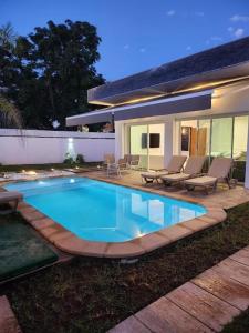 une piscine devant une maison dans l'établissement Villa H modern living steps from the beach, à Temara