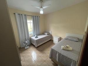 a bedroom with two beds and a fan and a window at Cantinho do Sossego - Piscina com Hidro! in São Lourenço +13 photos