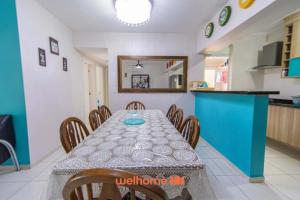 a dining room with a table and a kitchen at Apartamento em Bertioga a 500m da Praia de Indaiá in Ilha Monte Pascoal