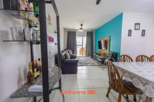 a kitchen and dining room with a table and a room at Apartamento em Bertioga a 500m da Praia de Indaiá in Ilha Monte Pascoal