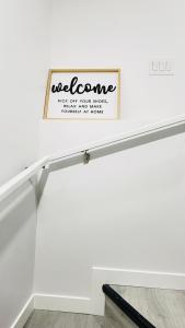 a white stair railing with a welcome sign on the wall at Ivey Homes in Edmonton