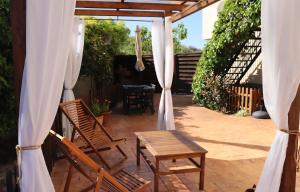 un patio avec des chaises et une table avec des rideaux dans l'établissement Apartamento rural NÍVALIS, à Nívar
