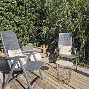 2 Stühle und ein Tisch auf einer Terrasse in der Unterkunft L'Eden Mobil Home à 200m de la plage Camping 5 étoiles Parc Aquatique in Torreilles + 36 Fotos