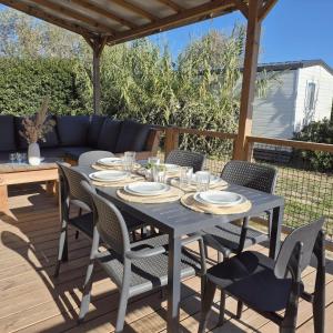 einen blauen Tisch und Stühle auf einer Terrasse in der Unterkunft L'Eden Mobil Home à 200m de la plage Camping 5 étoiles Parc Aquatique in Torreilles