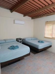 a room with two beds and a window at Nilka sunset house in Colón