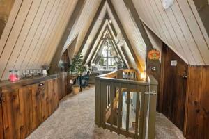 a attic room with wooden walls and a roof at Hot Tub A-Frame Cabin Lake Arrowhead Escape in Rimforest