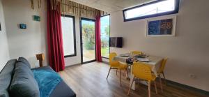 una sala de estar con un sofá, una mesa y sillas en Casas Floeca, en Jardim do Mar