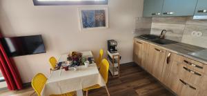 una pequeña cocina con mesa y sillas amarillas en Casas Floeca, en Jardim do Mar