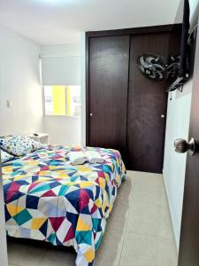 une chambre avec un lit avec une couette colorée dans l'établissement Apartamento Bucaramanga, à Bucaramanga 15 autres photos