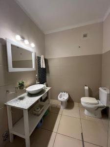 a bathroom with a sink and a toilet and a mirror at Chalet en zona Güemes-SOLO FAMILIAS in Mar del Plata