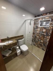 a bathroom with a toilet and a shower and a sink at Casa Familiar da Mari in São Gabriel +7 photos