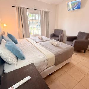 a bedroom with a large bed and two chairs at G8 Hermoso Monoambiente con Cochera 2 huéspedes in Villa Ángela