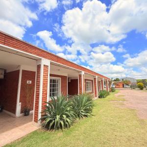 a red brick building with plants in front of it at G8 Hermoso Monoambiente con Cochera 2 huéspedes in Villa Ángela