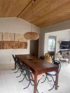 Un comedor con mesa y sillas de madera. en Little Oneroa Beach Bach, en Waiheke Island