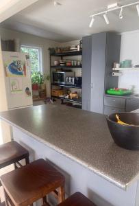 Una cocina con una encimera con un cuenco encima. en Little Oneroa Beach Bach, en Waiheke Island 9 fotos más