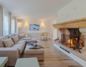 een woonkamer met een bank en een open haard bij Mountain Residence in Kandersteg