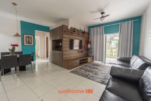 a living room with a couch and a dining room at Apto em Bertioga a beira mar com varanda gourmet in Ilha Monte Pascoal