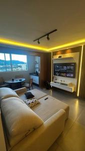 un soggiorno con un grande divano e una TV di Royal Blue Park Premium a Poços de Caldas