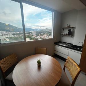 una cucina con tavolo in legno e una grande finestra di Royal Blue Park Premium a Poços de Caldas