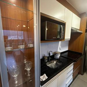 una cucina con lavello e microonde di Royal Blue Park Premium a Poços de Caldas
