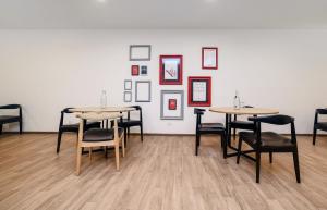 新德里Hotel O Qotel Hotel chhatarpur的墙上有桌椅的房间