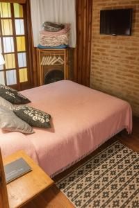 a bedroom with two beds and a table and a television at Cabaña en El Pinar de La lucila del mar -de un piso-, El Pinar -6 personas- in La Lucila del Mar