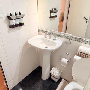 ein Badezimmer mit Waschbecken, Toilette und Spiegel in der Unterkunft G6 Monoambiente King con Cochera en Villa Ángela in Villa Ángela + 7 Fotos