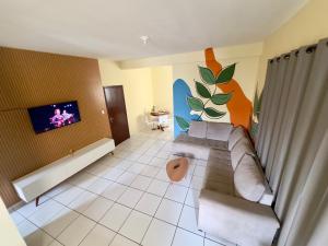 a living room with a couch and a tv at Loft Central Orgânico in Passos