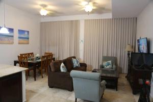 a living room with a couch and a table at Ocean Bliss: Balcony & Pools & Peloton Bike! in Lowlands