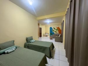 a hotel room with two beds and a couch at Loft Central Orgânico in Passos