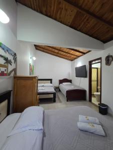 a hotel room with two beds and a television at Hotel Monte verde in Salento
