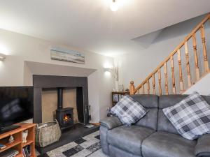 a living room with a couch and a fireplace at The Croft House in Muir of Ord