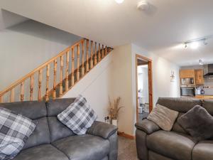 a living room with two couches and a staircase at The Croft House in Muir of Ord +14 photos